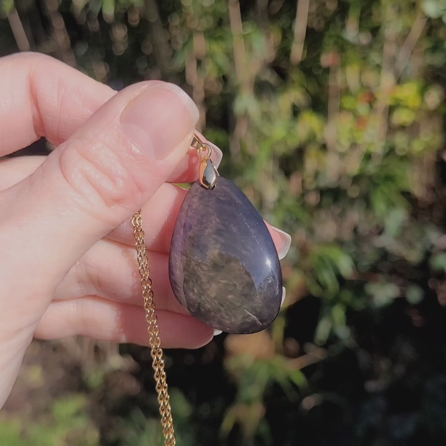 Vidéo rotation pendentif obsidienne manta huichol montrant reflets changeants violet vert doré