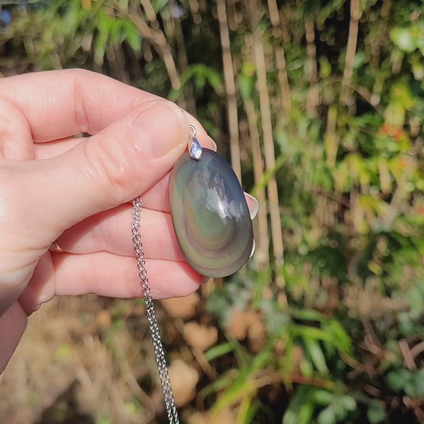 Vidéo rotation pendentif obsidienne œil céleste montrant couches et reflets lumineux
