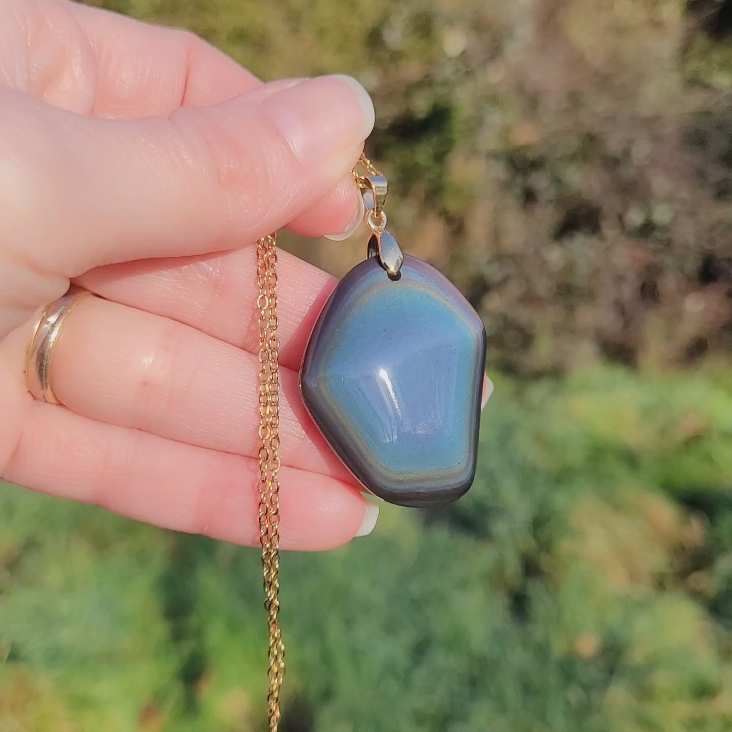 Vidéo rotation pendentif forme libre obsidienne œil céleste montrant couches et reflets bleus au caractère unique 