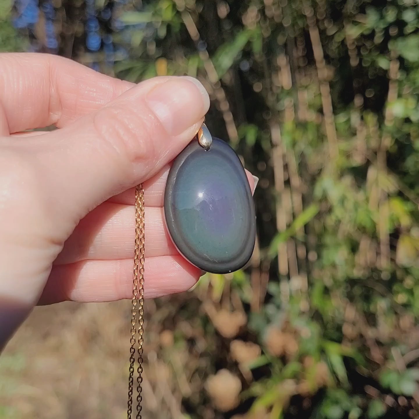 Vidéo rotation pendentif obsidienne œil céleste montrant couches et reflets bleu/vert