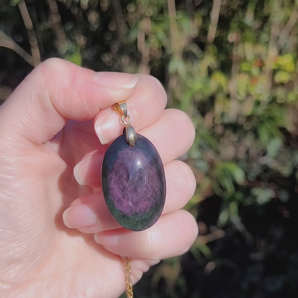 Vidéo rotation pendentif obsidienne manta huichol montrant reflets changeants violet vert