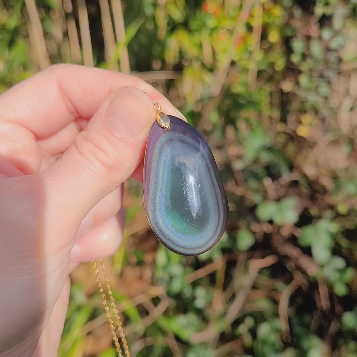 Vidéo rotation pendentif forme libre obsidienne œil céleste montrant couches et reflets violet vert bleu