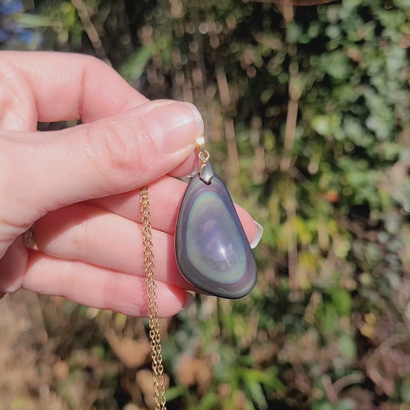 Vidéo rotation pendentif obsidienne œil céleste montrant couches et reflets multicolores