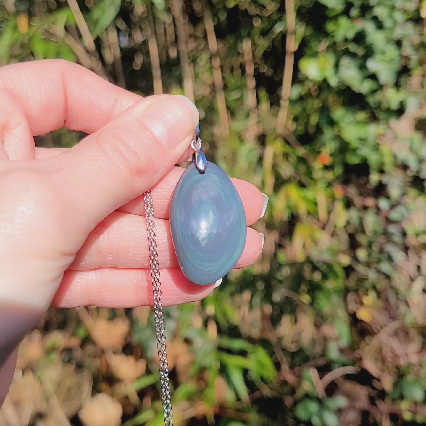 Vidéo rotation pendentif obsidienne œil céleste montrant couches et reflets bleu pastel et nacré